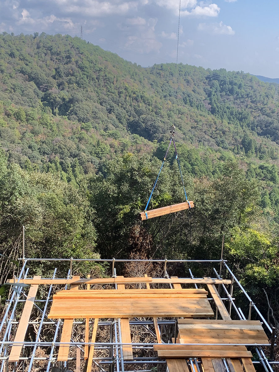 写真⑥ ホイストによる建材の荷下ろし